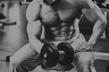 Vücut geliştirmeci yapar egzersiz jimnastik salonu dumbbells ile.