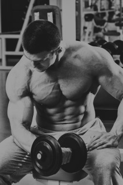 Vücut geliştirmeci yapar egzersiz jimnastik salonu dumbbells ile.