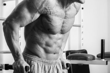 Kaslı adam spor salonunda ağırlık ile çalışma dışarı. Adam egzersizleri yapar.