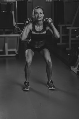 Seksi sarışın kaslı vücudu spor salonunda eğitiyor. Spor sarışın. Güçlü kız.