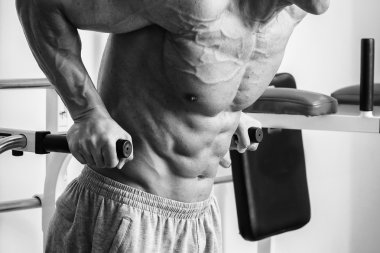 Kaslı adam spor salonunda ağırlık ile çalışma dışarı. Adam egzersizleri yapar.