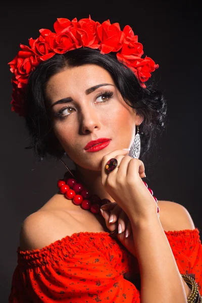 Portrait d'une belle jeune femme en robe rouge et noire sur fond sombre . — Photo