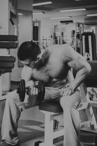 Man op de sportschool. Man maakt oefeningen met barbell. — Stockfoto