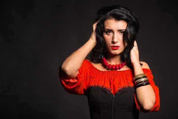 Mujer elegante y sexy en un vestido rojo. Retrato de la hermosa morena en rojo en el estudio. Retrato emocional . —  Fotos de Stock