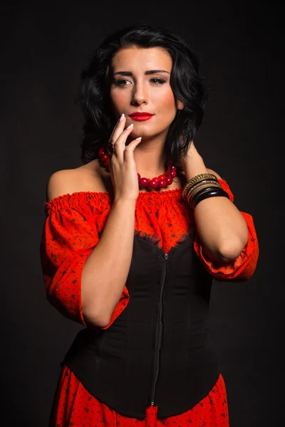 Mujer elegante y sexy en un vestido rojo. Retrato de la hermosa morena en rojo en el estudio. Retrato emocional . — Foto de Stock