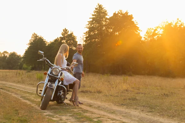Motorcu ve bir motosiklet üzerinde bir alanda güzel kız.