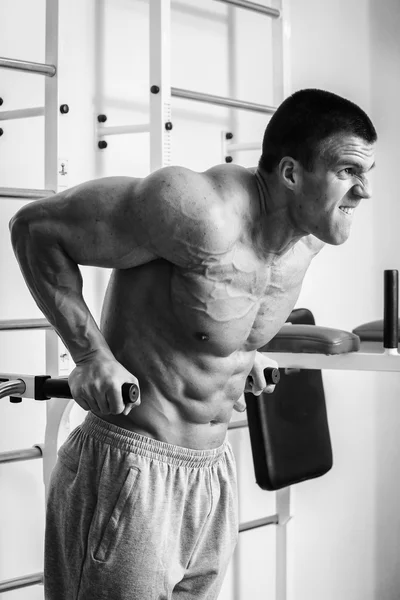 Muscular man working out with weights in gym. Man makes exercises. — Stock Photo, Image