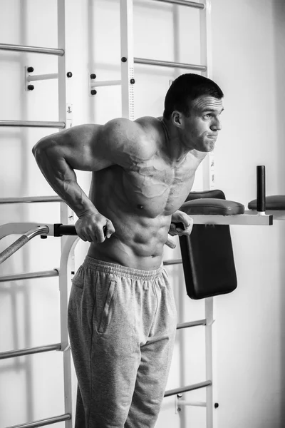 Muscular man working out with weights in gym. Man makes exercises. — Stock Photo, Image