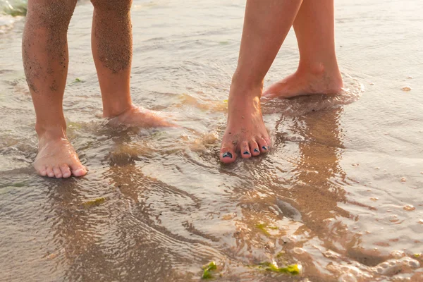 Foot on sea sand. Women's and children's feet in the sand. Beautiful pedicure. Photo for fashion, travel, social magazines and websites. A beautiful photo for background. — Stock Photo, Image