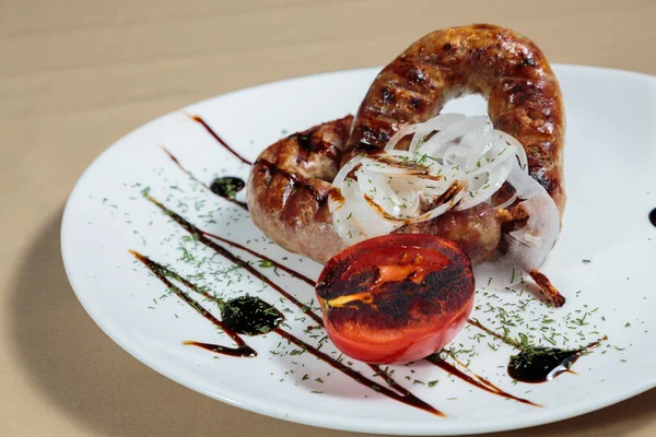 Izgarada pişirme. Izgara sosis kızartma. Izgara menü. Domuz sosisi bir plaka üzerinde.