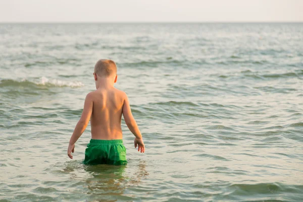 Pantaloncini da ragazzo sulla spiaggia. Bambini che giocano con la sabbia marina. Gioia e divertimento per i bambini. Una bella giornata calda. Foto per riviste e siti web per bambini . — Foto Stock