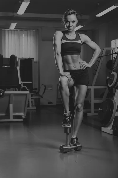 Loira sexy treina seu corpo muscular no ginásio. Loira desportiva. Menina forte . — Fotografia de Stock