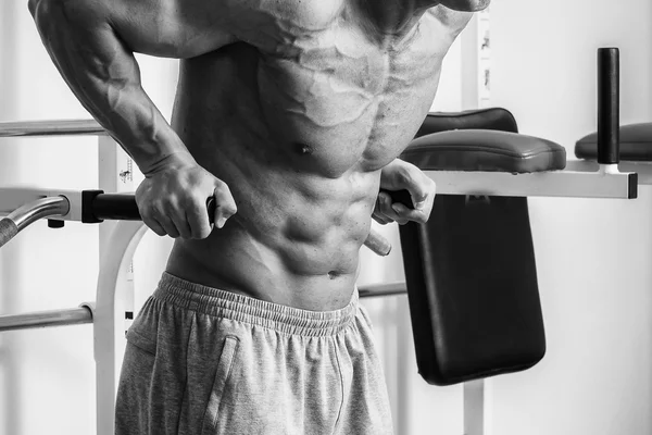 Hombre musculoso haciendo ejercicio con pesas en el gimnasio. El hombre hace ejercicios . —  Fotos de Stock