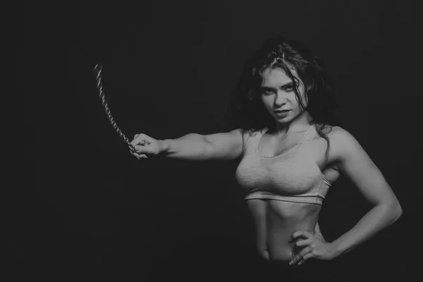 A menina de esportes com um pedaço de corrente metálica em fundo escuro. Menina bonita posando para a cadeia da câmera alongamento. O belo atletky de corpo de esportes. Fotos para revistas esportivas, sites . — Fotografia de Stock