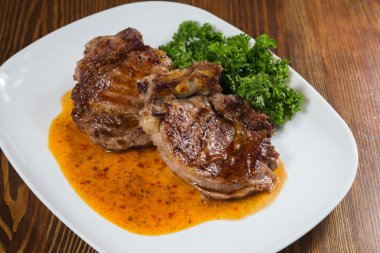 Dana rosto bir tabakta sebze ile bir tavada.