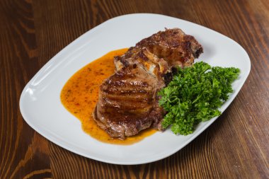 Dana rosto bir tabakta sebze ile bir tavada.