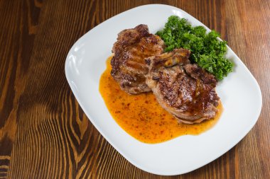 Dana rosto bir tabakta sebze ile bir tavada.