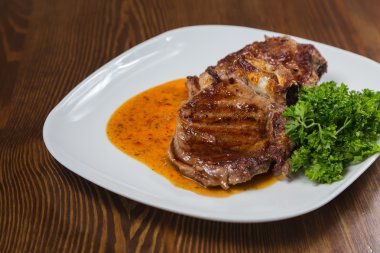 Dana rosto bir tabakta sebze ile bir tavada.