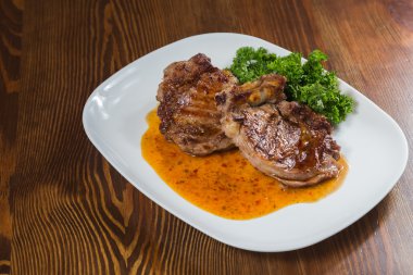 Dana rosto bir tabakta sebze ile bir tavada.