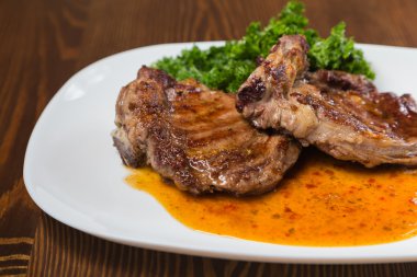 Dana rosto bir tabakta sebze ile bir tavada.