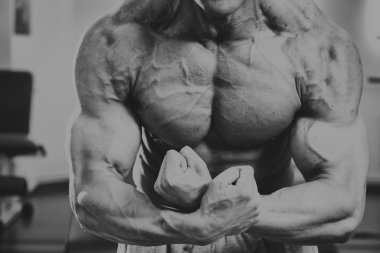 Spor salonunda yakışıklı, atletik, kendine güvenen adam. vücut geliştirme poz