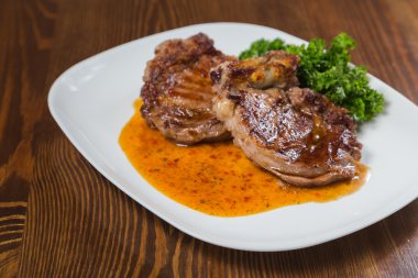 Dana rosto bir tabakta sebze ile bir tavada.