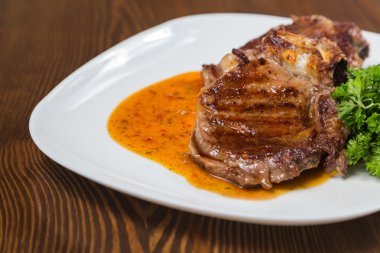 Dana rosto bir tabakta sebze ile bir tavada.