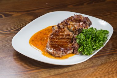 Dana rosto bir tabakta sebze ile bir tavada.