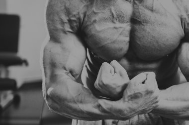 Spor salonunda yakışıklı, atletik, kendine güvenen adam. vücut geliştirme poz