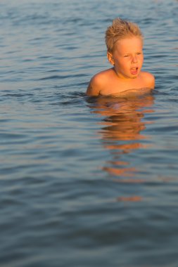 5 yıl denizde oynayan bir çocuk. Bir çocuk denizde yüzüyor.