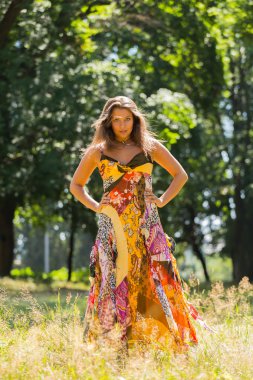 Güneşli Çayırlar orta elbise güzel yaz aylarında genç ve çekici bir kız. Neşeli kız yaz güneş sıcak ışınlarının tadını çıkarma. Kaygısız bir kız güzel görüntüsü.