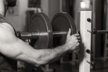 Vücut geliştirme dumbbells ile. Husky büyük bir dumbbell elinde tutar. Spor, vücut geliştirme, sağlıklı yaşam tarzı.