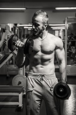 Adam jimnastik salonu. Egzersiz halter kılıyor. Spor, güç, halter, gerginlik, egzersiz - sağlıklı bir yaşam tarzı kavramı. Fitness ve spor hakkında makale.