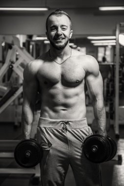 Adam jimnastik salonu. Egzersiz halter kılıyor. Spor, güç, halter, gerginlik, egzersiz - sağlıklı bir yaşam tarzı kavramı. Fitness ve spor hakkında makale.