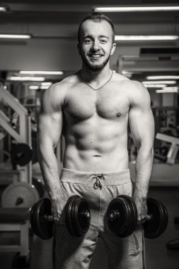 Adam jimnastik salonu. Egzersiz halter kılıyor. Spor, güç, halter, gerginlik, egzersiz - sağlıklı bir yaşam tarzı kavramı. Fitness ve spor hakkında makale.