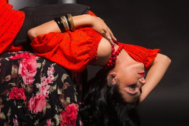 Kırmızı bir elbise şık ve seksi kadın. Güzel esmer kırmızı stüdyoda portresi. Duygusal portre.