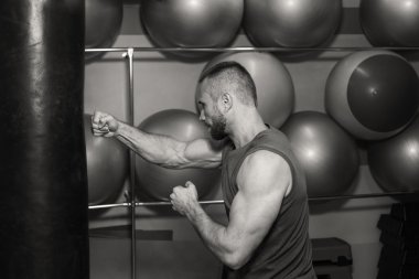 Jimnastik salonu kas adam. Kum torbasına yaşına, egzersiz. Boks, egzersiz, kas, güç, güç - eğitim ve boks gücü kavramı