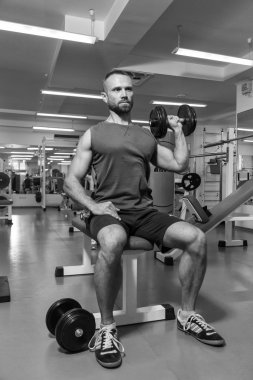 Vücut geliştirme dumbbells ile. Husky büyük bir dumbbell elinde tutar. Spor, vücut geliştirme, sağlıklı yaşam tarzı.