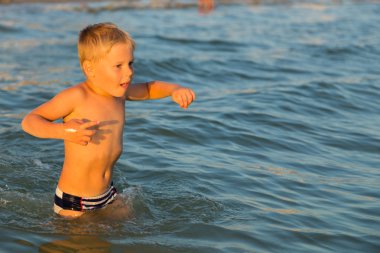 5 yıl denizde oynayan bir çocuk. Bir çocuk denizde yüzüyor.
