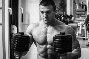 Vücut geliştirme dumbbells ile. Husky büyük bir dumbbell elinde tutar. Spor, vücut geliştirme, sağlıklı yaşam tarzı.