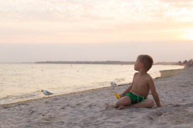 Sahilde erkek şort. Deniz kum ile oynayan çocuk. Sevinç ve eğlenceli çocuklar için. Güzel sıcak bir gün. Çocuk dergi ve Web siteleri için fotoğraf.