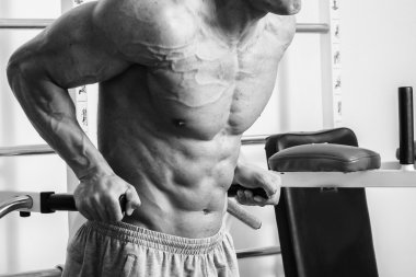 Kaslı adam spor salonunda ağırlık ile çalışma dışarı. Adam egzersizleri yapar.