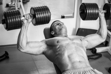 Vücut geliştirme dumbbells ile. Husky büyük bir dumbbell elinde tutar. Spor, vücut geliştirme, sağlıklı yaşam tarzı.