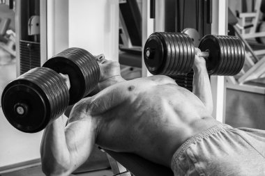 Vücut geliştirme dumbbells ile. Husky büyük bir dumbbell elinde tutar. Spor, vücut geliştirme, sağlıklı yaşam tarzı.