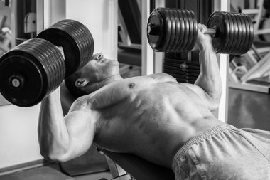 Vücut geliştirme dumbbells ile. Husky büyük bir dumbbell elinde tutar. Spor, vücut geliştirme, sağlıklı yaşam tarzı.