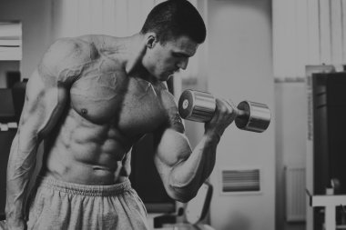Vücut geliştirmeci yapar egzersiz jimnastik salonu dumbbells ile.