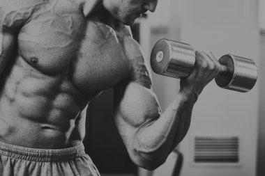 Vücut geliştirmeci yapar egzersiz jimnastik salonu dumbbells ile.