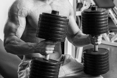 Vücut geliştirmeci yapar egzersiz jimnastik salonu dumbbells ile.