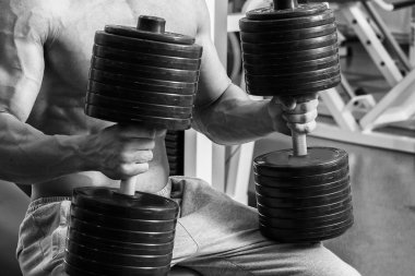 Vücut geliştirmeci yapar egzersiz jimnastik salonu dumbbells ile.