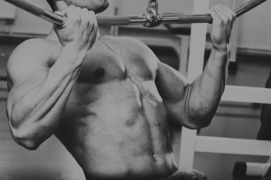 Bench halter salonunda. Kaslı adam yorucu egzersiz yapmak. Siyah beyaz fotoğraf kaslı adam. Fotoğraflar spor dergi ve Web siteleri için.